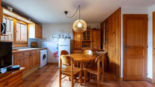 une cuisine avec une table en bois et un réfrigérateur dans l'établissement LE CHAMOIS - 15 - Appt pres des pistes 4 pers, à Morillon