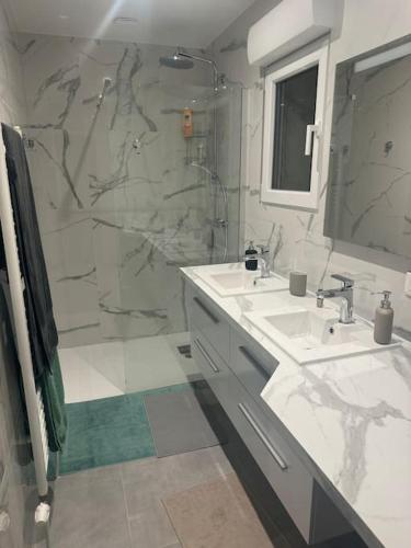 une salle de bain avec deux lavabos et une douche dans l'établissement Appartement neuf 2 chambres 8 Couchages, à Les Alluets-le-Roi