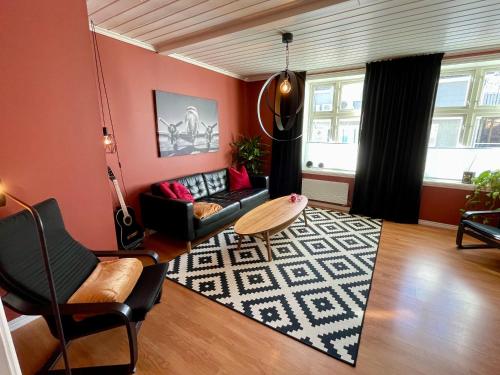 a living room with a couch and a rug at Sentral og fargerik bygårdsleilighet in Halden