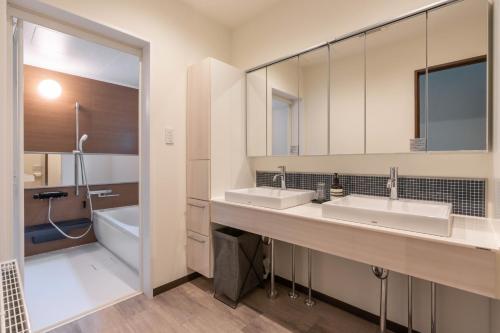 ein Badezimmer mit zwei Waschbecken und einem großen Spiegel in der Unterkunft green leaf rusutsu - Vacation STAY 87362v in Rusutsu