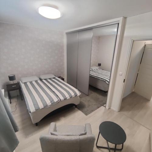 1 dormitorio con cama, silla y espejo en SEA - 3 Bedrooms, en Kristinestad