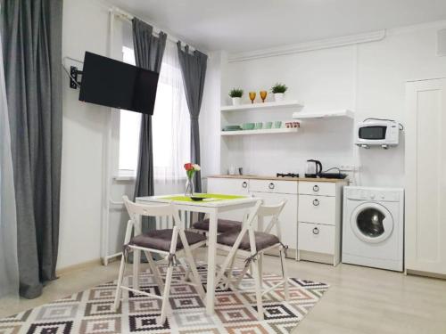 a kitchen with a table and chairs in a room at Милая Студия 2 in Atyrau