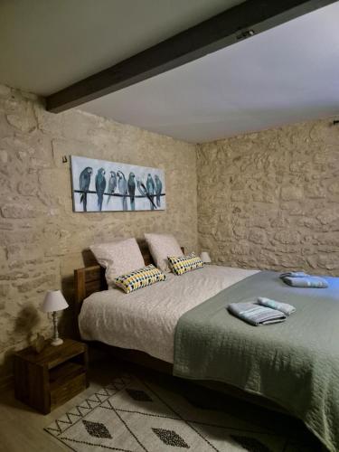 - une chambre avec un lit et un mur en pierre dans l'établissement Domaine des Prés de Joussac - Protocole sanitaire strict, à Jau-Dignac-et-Loirac