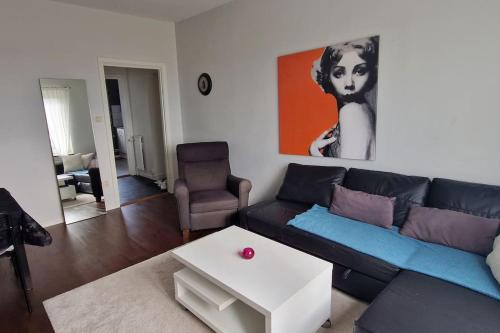 a living room with a black couch and a table at Fin lägenhet i närheten av stan och lasarettet in Motala