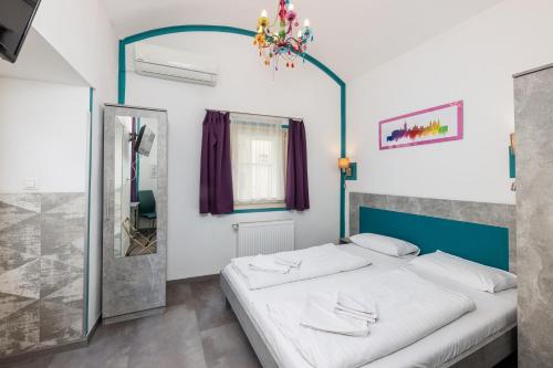 Amber Gardenview Studios Downtown في بودابست: غرفة نوم بسرير وثريا