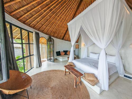 a bedroom with a canopy bed and a couch at Hillstone Luxury Village in Ungasan