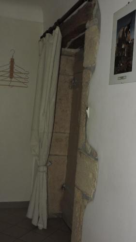 a room with a stone wall and a door with a curtain at Le Vendangeur in Chassey-Le-Camp