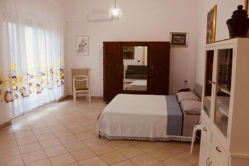 1 dormitorio con cama y espejo en Maison Luigi - Casa Vacanze1, en Nociglia