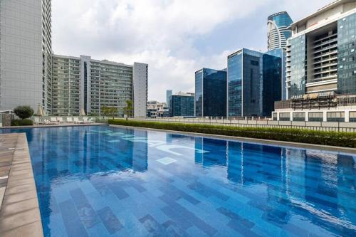 a large swimming pool in a city with tall buildings at Goldbest-Reva Burj Khalifa view in Dubai