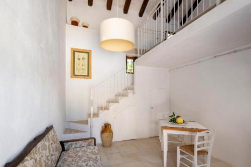un corridoio con pareti bianche, tavolo e scale di Masseria Caretti Grande a Casalabate