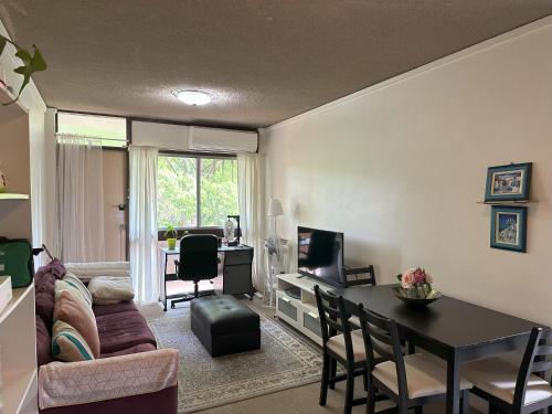 a living room with a table and a dining room at Macquarie Treetops - Sydney 2BR Apt with FREE parking at Macquarie Park in Sydney
