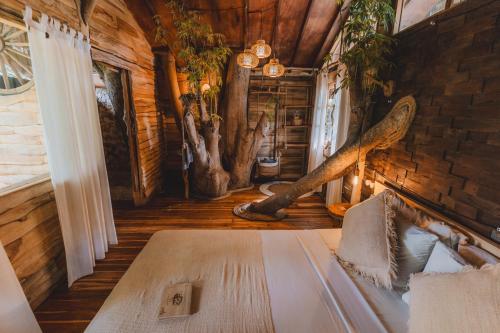 a bedroom with a bed in a log cabin at Roots Tree House in Uluwatu