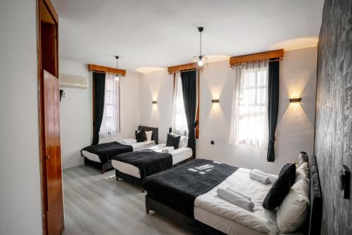 Habitación de hotel con 2 camas y sala de estar. en BÜTÜNOĞLU PANSİYON, en Antalya