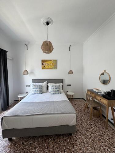 biała sypialnia z łóżkiem i biurkiem w obiekcie Blue Sardines w mieście Pitagorio