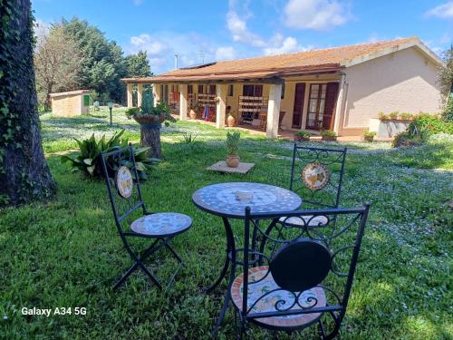 a table and chairs in the yard of a house at Agriturismo Bio Pian Dei Casali in Saturnia