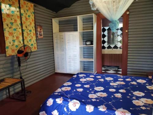 Un dormitorio con una cama azul con flores. en Bungalow Chez Mouch Nosy Be 6, en Nosy Be