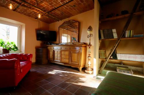 a living room with a red couch and a mirror at Villa Aurora Sotto Le Stelle in Torre Pellice