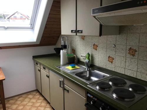 a kitchen with a sink and a stove and a window at Haus Imgard in Lenzkirch