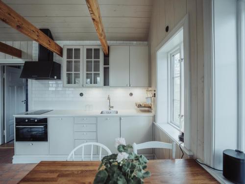 a kitchen with white cabinets and a table with a plant at Ytterön skärgårdshotell in Torhamn