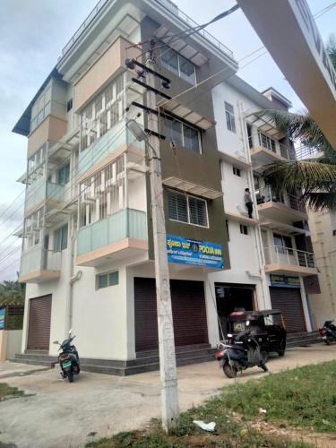 a building with motorcycles parked in front of it at Varuna Inn in Chāmundi