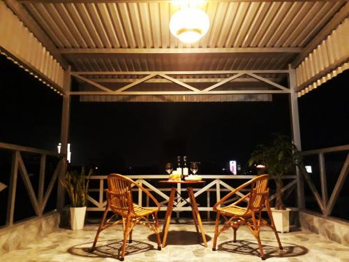 a patio with two chairs and a table at Adora Hostel in Can Tho