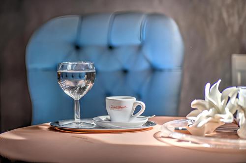 a table with a glass of wine and a coffee cup at AL GONDOLIERE in Oppach