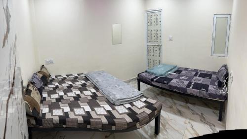 乌贾因Winter Hotel at Ujjain的两张床位于带性关节炎性关节炎性关节炎性关节炎性关节炎的房间