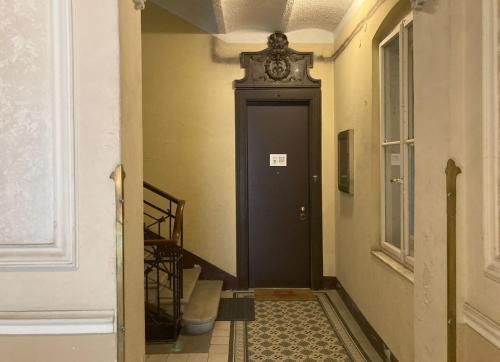 un corridoio con una porta nera con un orologio di Center Monflat a Trieste