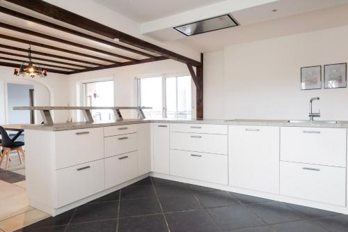 uma cozinha com armários brancos e um lavatório em Work & Stay Apartment Emmerich em Emmerich