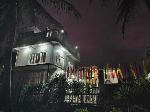 ein Gebäude mit Flaggen in der Nacht davor in der Unterkunft Private Home Ocean View Resort Talaonga in Sorsogon