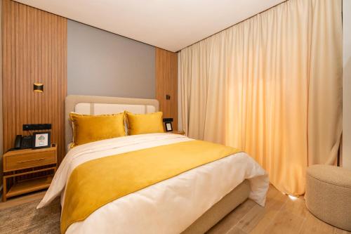 1 dormitorio con 1 cama grande con almohadas amarillas en Appart Hôtel Rambla, en Marrakech