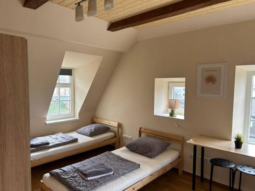 two beds in a room with two windows at Hostel Filaretai in Vilnius