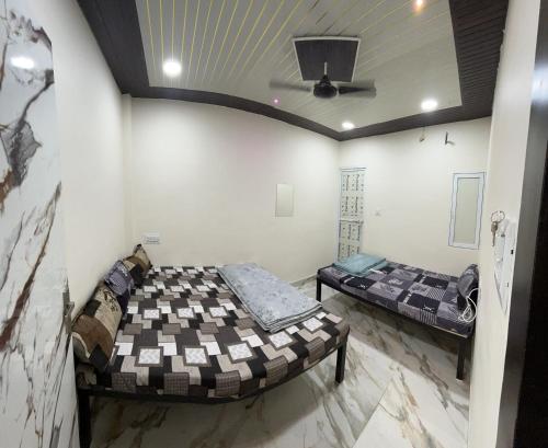 two beds in a room with a ceiling at Winter Hotel at Ujjain in Ujjain