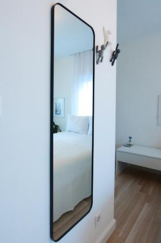 a mirror on a wall in a room with a bed at PRIMA APARTMENTS in Satu Mare