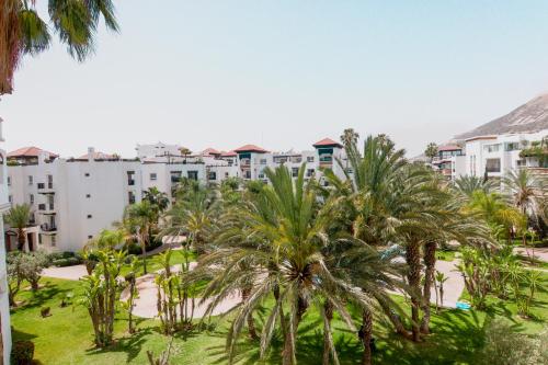 uma vista para um resort com palmeiras e edifícios em Bloom - Marina Agadir - Piscine - 4 or 5 Px em Agadir