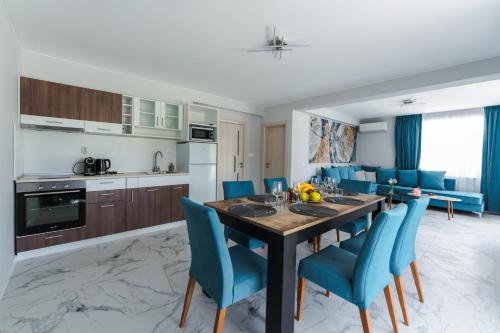 uma cozinha e sala de jantar com uma mesa e cadeiras azuis em ENEVI Guest Houses em Sandanski