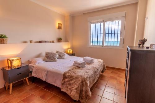 a bedroom with a bed and a window at RentitSpain Arce 1-13 Vista a la playa del mar Mediterráneo in Nerja