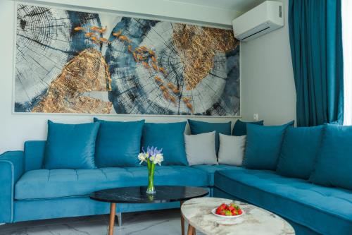 a blue couch in a living room with a map on the wall at ENEVI Guest Houses-Къщи за гости Еневи in Sandanski