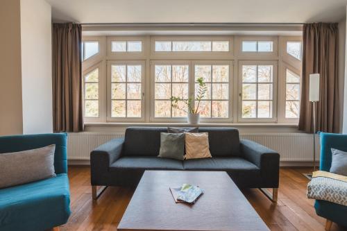 奧斯特魯茲納的住宿－Theresian Apartment，客厅配有2张蓝色的沙发和1张桌子