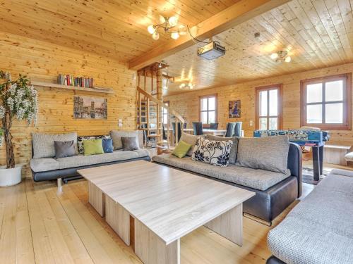 a living room with couches and a table at Detached wooden chalet in Liebenfels Carinthia near the Simonh he ski area in Liebenfels