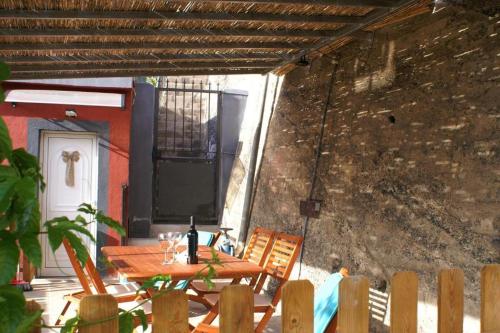 a patio with a table and chairs and a brick wall at Vivienda Vacacional Cuenca de Liria in Hermigua