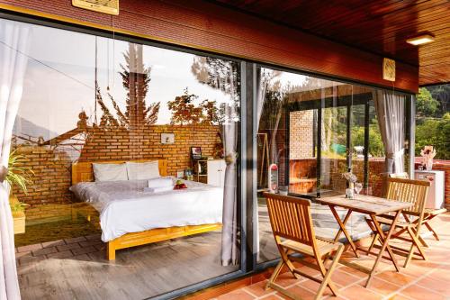 - une chambre avec un lit et une table sur une terrasse dans l'établissement Scent Bungalow - Village, à Đà Lạt