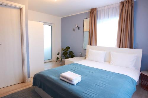 a bedroom with a large bed with a blue blanket at PRIMA APARTMENTS in Satu Mare