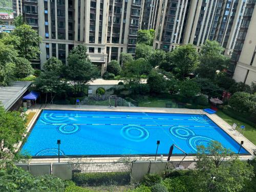 a large blue swimming pool with buildings in the background at Pikkie Designer's Stylish Three Bed Room Apartmemt in Zhangjiajie