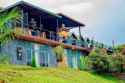 a house on a hill with people on the balcony at GOOD MOOD BEACH RESORT LTD in Rwamagana