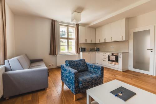 een woonkamer met een bank, een stoel en een tafel bij Theresian Apartment in Ostružná