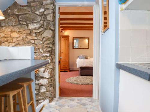 eine Küche und ein Wohnzimmer mit einer Steinmauer in der Unterkunft Granary Studio in Gloucester