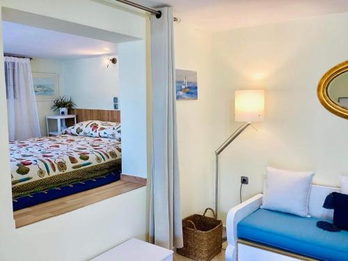 Cette petite chambre comprend un lit et un miroir. dans l'établissement The Blue House, à Vromolithos