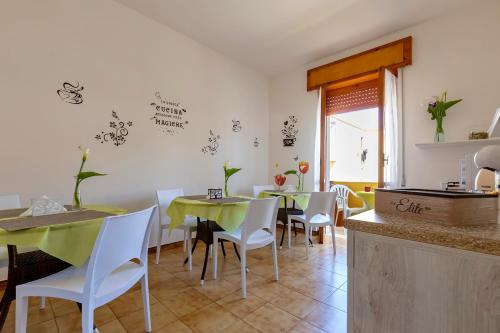 a dining room with green tables and white chairs at Sardinia rooms in Alghero