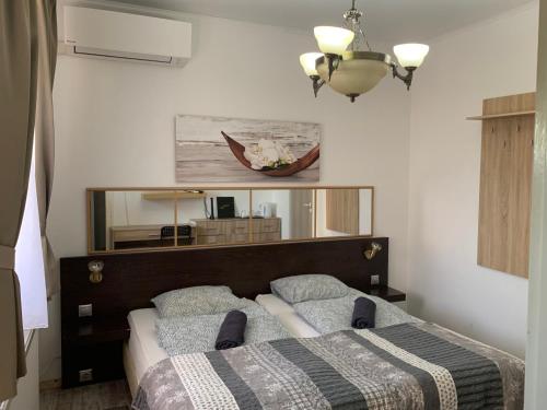 sypialnia z łóżkiem i dużym lustrem w obiekcie Toscan Panzió w mieście Gyál